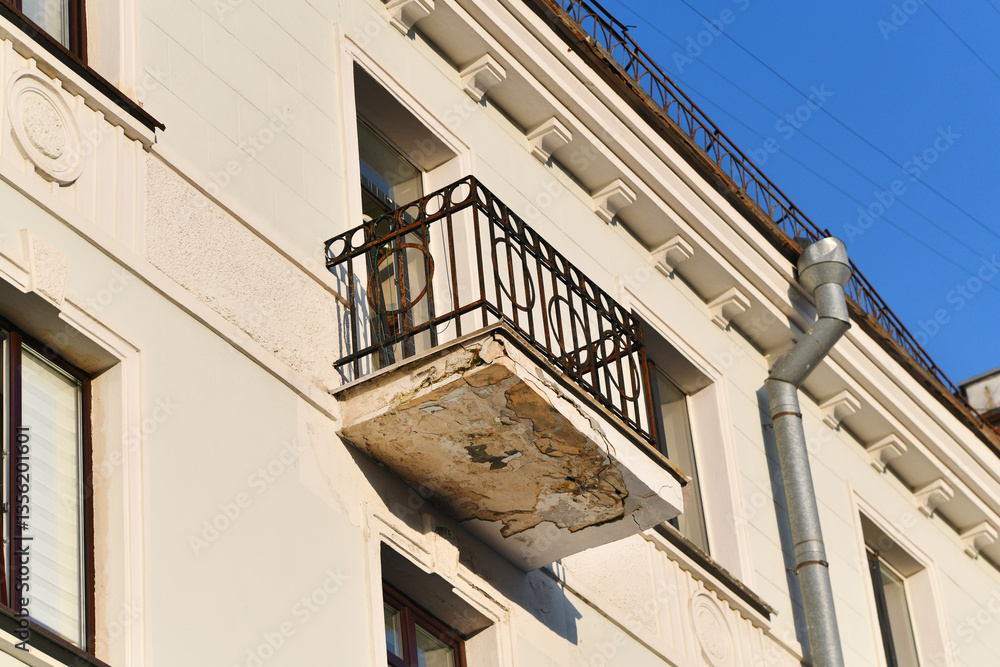 Old apartment balcony with cracked concrete and corroded metal railing, structural damage, neglect, weathering need for repair. Deteriorating balcony with rusted railing and crumbling concrete floor