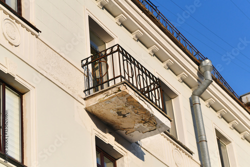 Obraz na płótnie Old apartment balcony with cracked concrete and corroded metal railing, structural damage, neglect, weathering need for repair. Deteriorating balcony with rusted railing and crumbling concrete floor w salonie