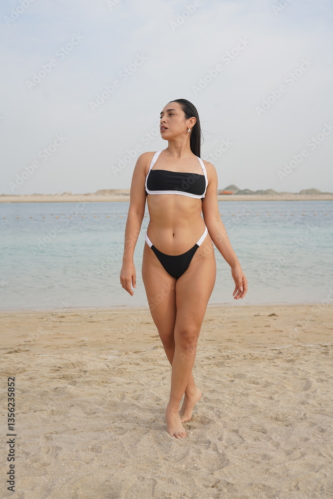 Confident Woman Posing in Bikini and Hat on a Sunny Beach Confident Woman Posing in Bikini and Hat on a Sunny Beach