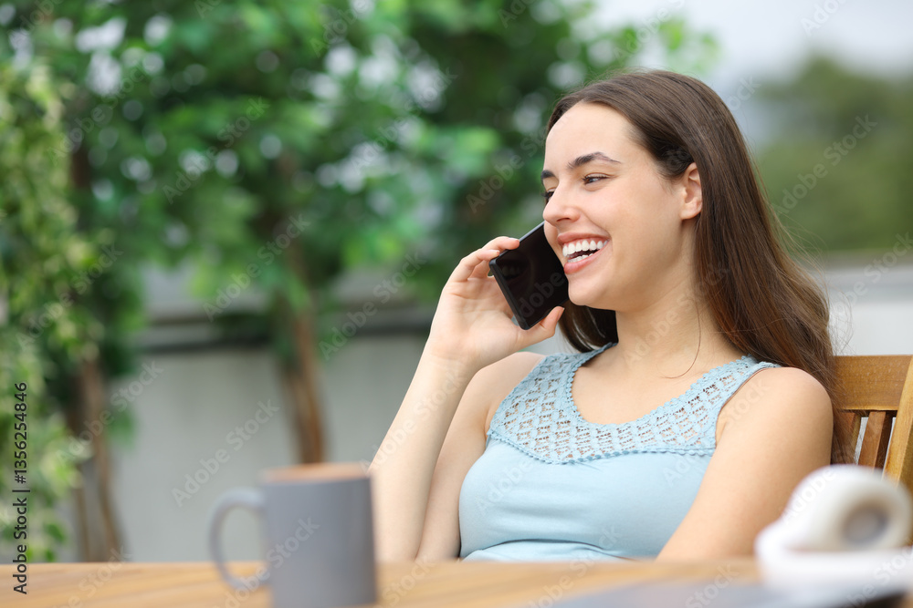 Happy woman in a terrace talking on phone Happy woman in a terrace talking on phone