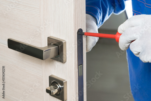 the master corrects the door lock design with a screwdriver