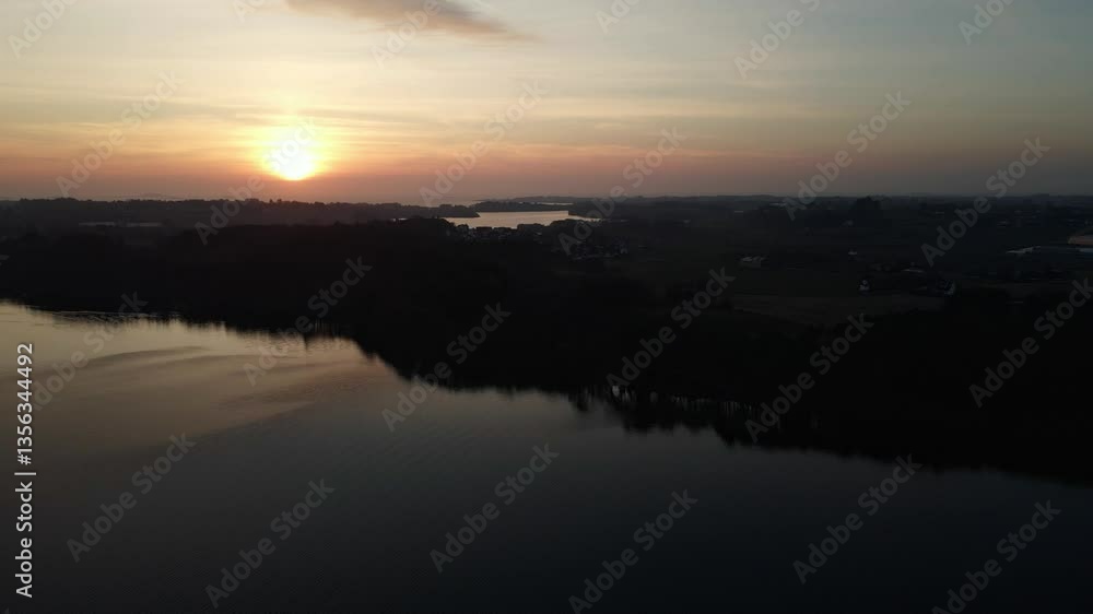 Aerial Drone Shot at Dusk Over Stokkavatn Lake with Silhouetted Landscape Aerial Drone Shot at Dusk Over Stokkavatn Lake with Silhouetted Landscape