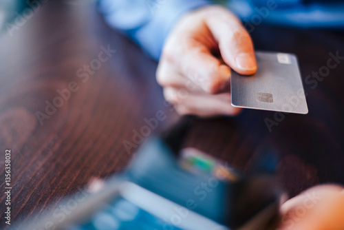 Close-up of a hand holding a credit card for a digital payment transaction