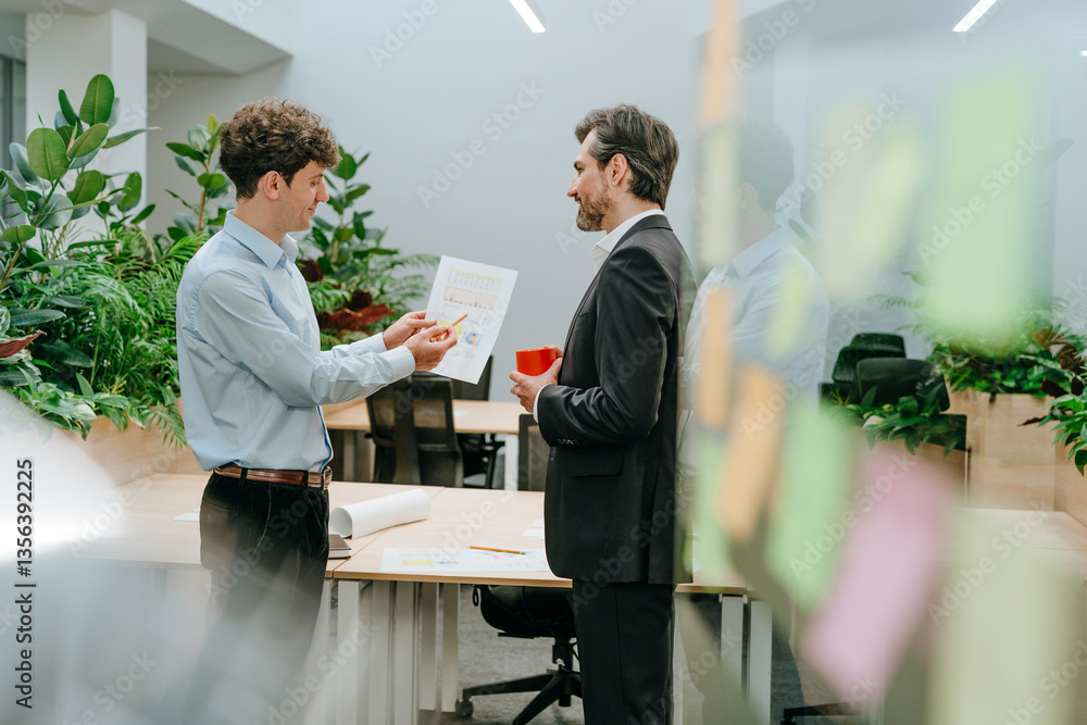 Businessmen discussing documents in a modern office environment Businessmen discussing documents in a modern office environment