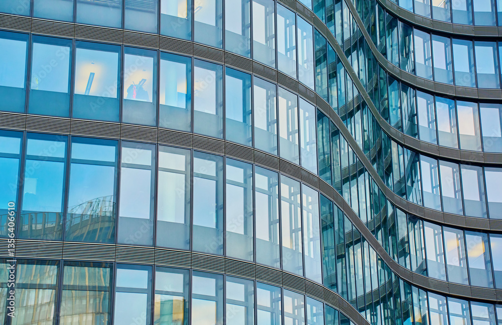 Modern curved high rise building. Glass facade of skyscraper. Office building exterior. Contemporary architectural design