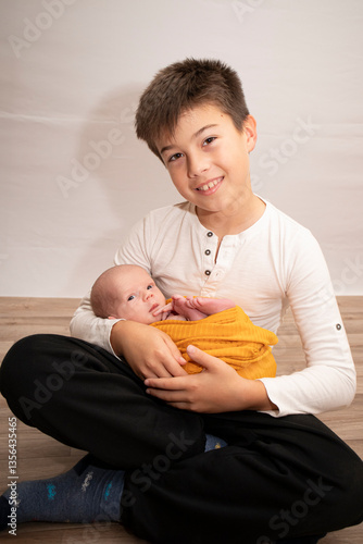 Older brother holding newborn sibling