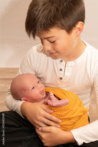 Older brother holding newborn sibling