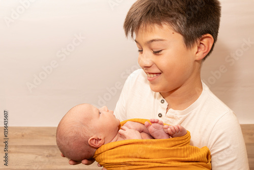 Older brother holding newborn sibling
