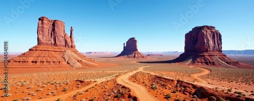 View of the iconic Mittens rock formations in Monument Valley under a clear blue sky,  desert,  tourism