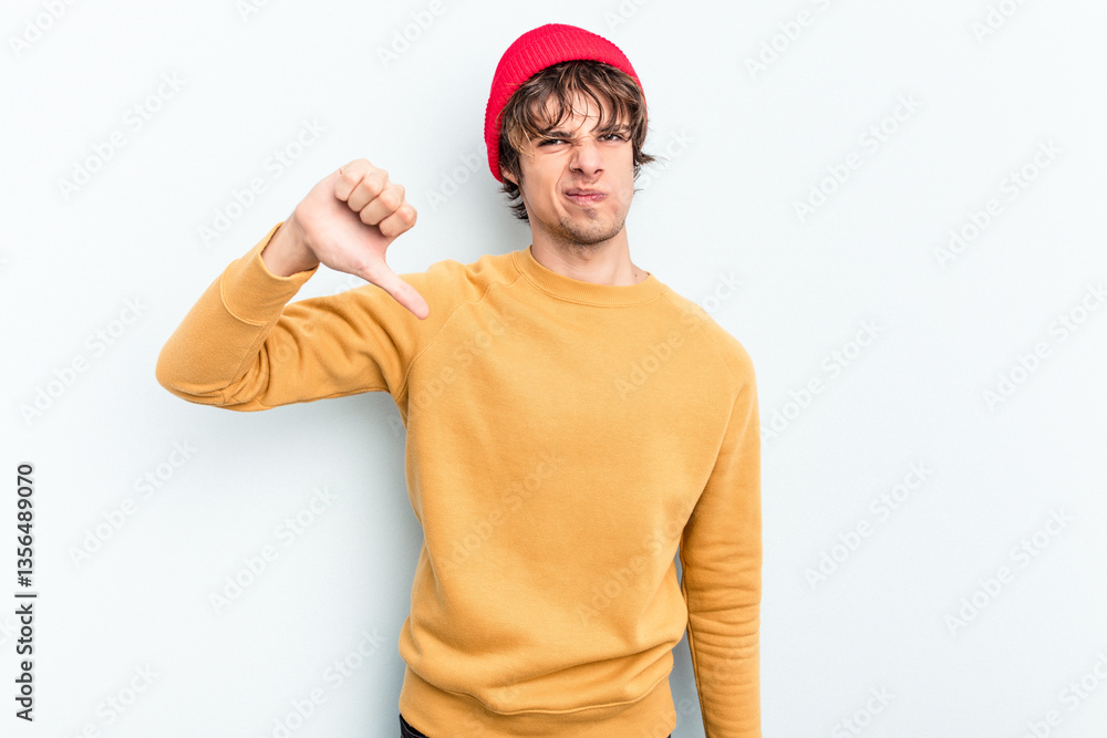 Young caucasian man isolated on blue background showing thumb down and expressing dislike. Young caucasian man isolated on blue background showing thumb down and expressing dislike.