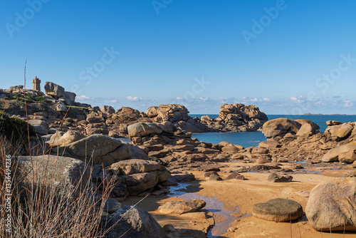 Les célèbres rochers de la côte de Granit Rose, sous un ciel bleu, avec une mer calme et scintillante. 