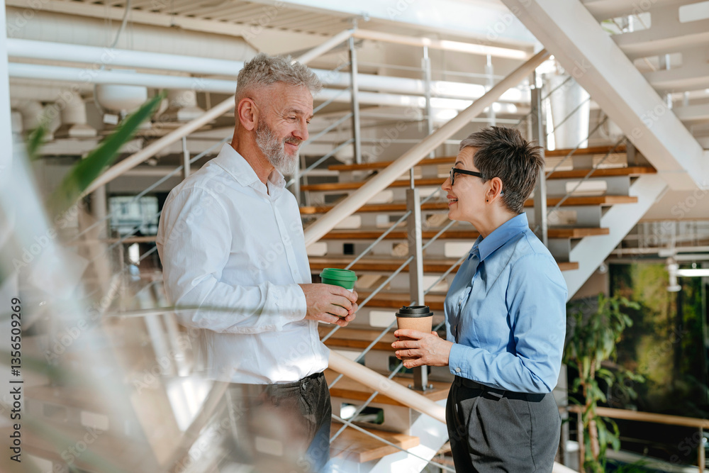 Business people having a conversation on office stairs Business people having a conversation on office stairs