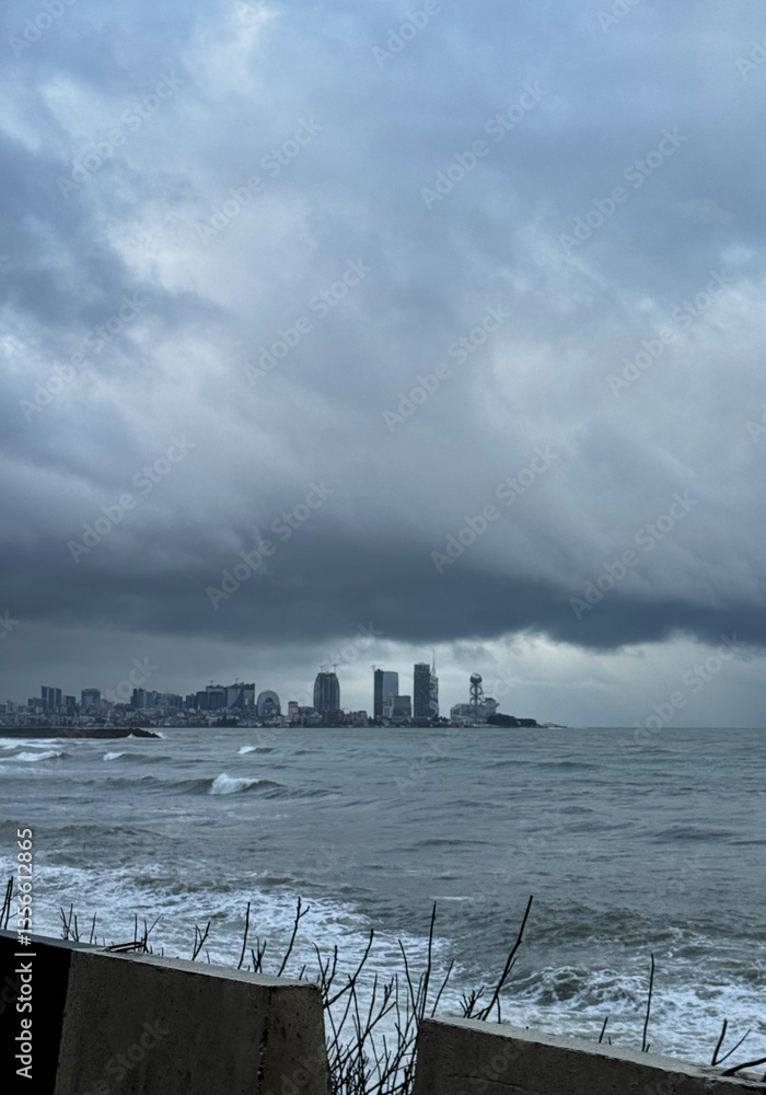 City skyline under stormy sky by the ocean