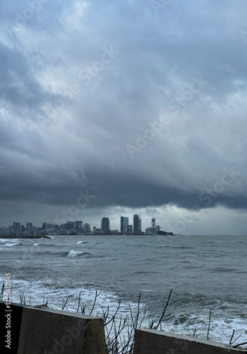 Obraz na płótnie City skyline under stormy sky by the ocean w salonie