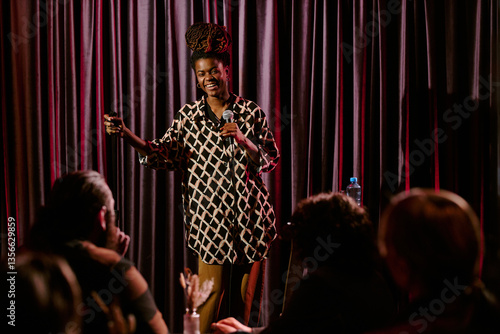 Fotografie Person delivering stand-up comedy routine on stage holding microphone engaging w