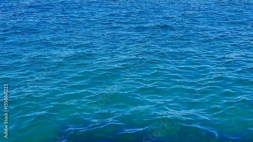 Beautiful blue sea and large calm waves .