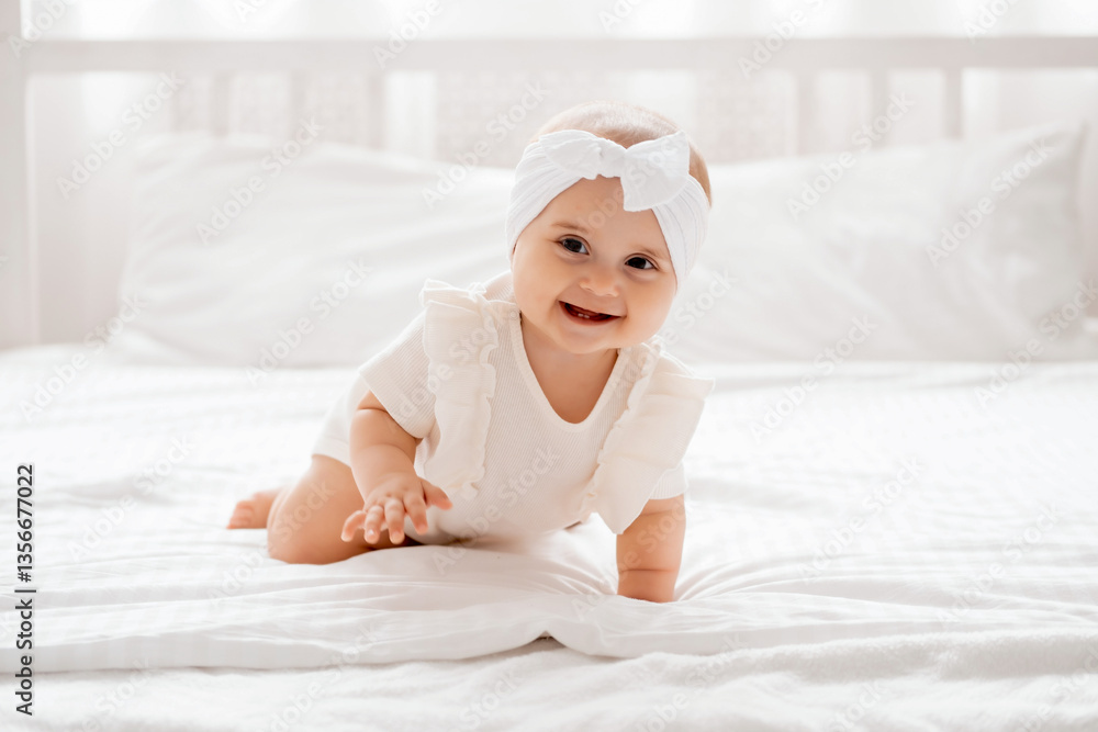 smiling baby girl laughing crawling on a bed in white clothes in smiling baby girl laughing crawling on a bed in white clothes in