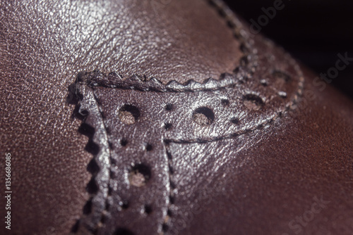 new brown leather shoe with laces on dark background close up