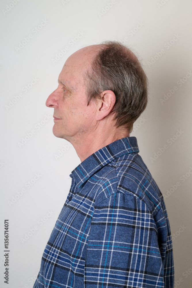 Senior man with a cotton shirt against white wall