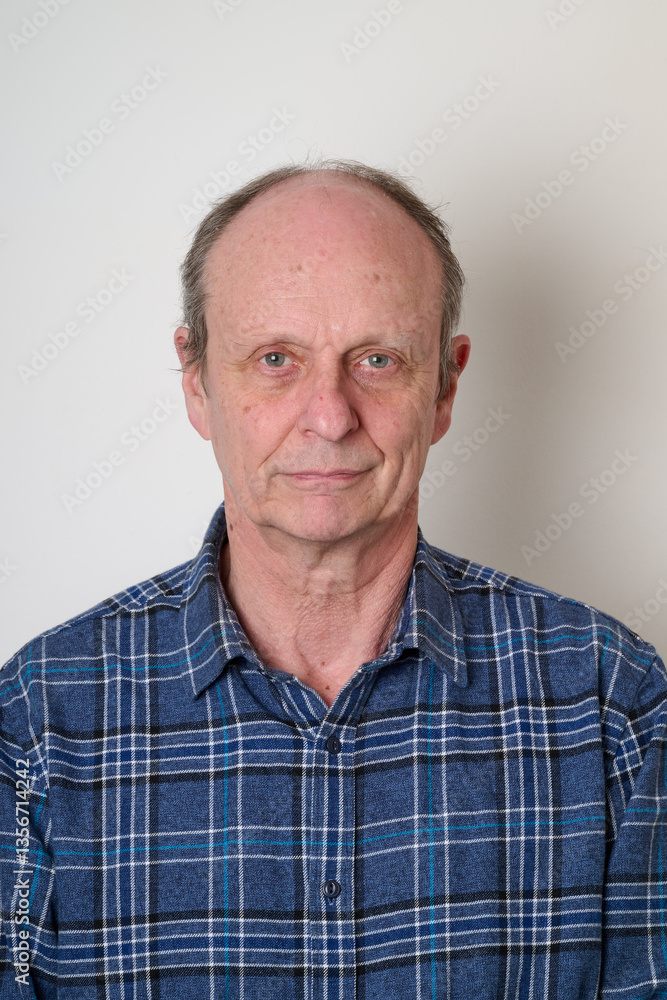 Senior man with a cotton shirt against white wall