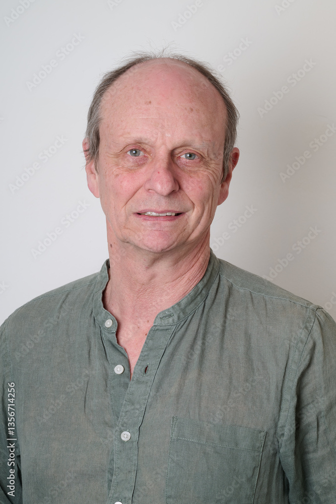 Senior man with a cotton shirt against white wall