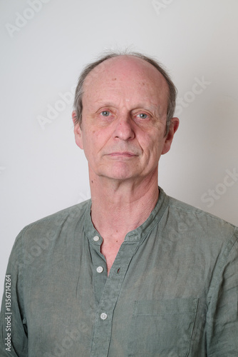 Senior man with a cotton shirt against white wall