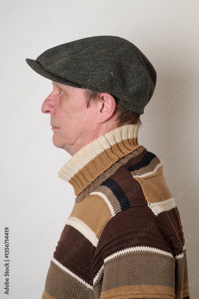 Senior man with a beige turtleneck puulover and a vintage cap