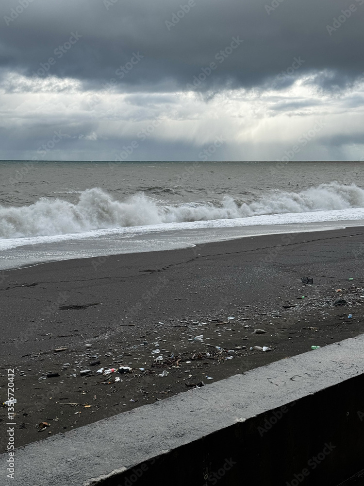 Stormy beach with dark clouds and polluted shore