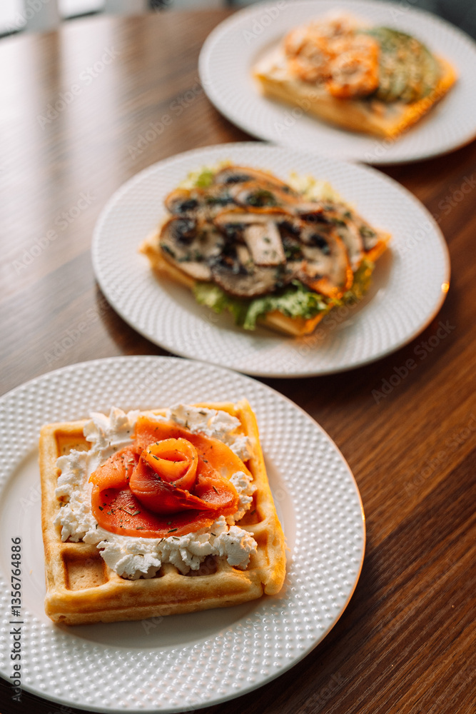 Different types of salty waffles with egg, mushrooms, salmon, mushrooms for breakfast