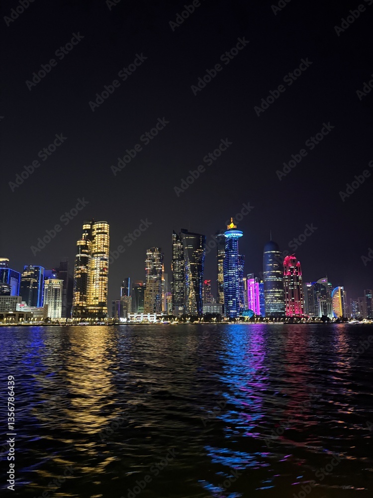 Fototapeta premium Doha skyline by night in Doha, view from a boat at the corniche