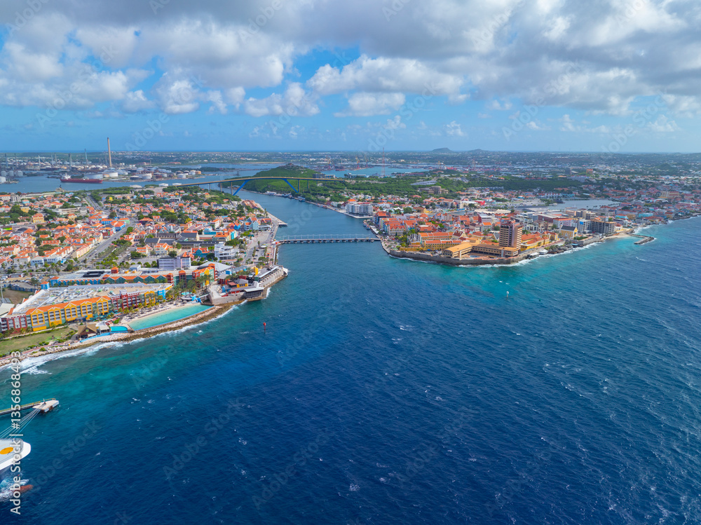 Fototapeta premium Willemstad historic city center aerial view including Otrobanda on the left and Punda on the right in city of Willemstad, Curacao. Historic Willemstad is a UNESCO World Heritage Site. 