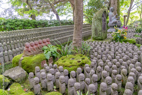 Many rows of Buddha statues in this Japanese temple garden at Hase-dera Temple in Kamakura, Japan