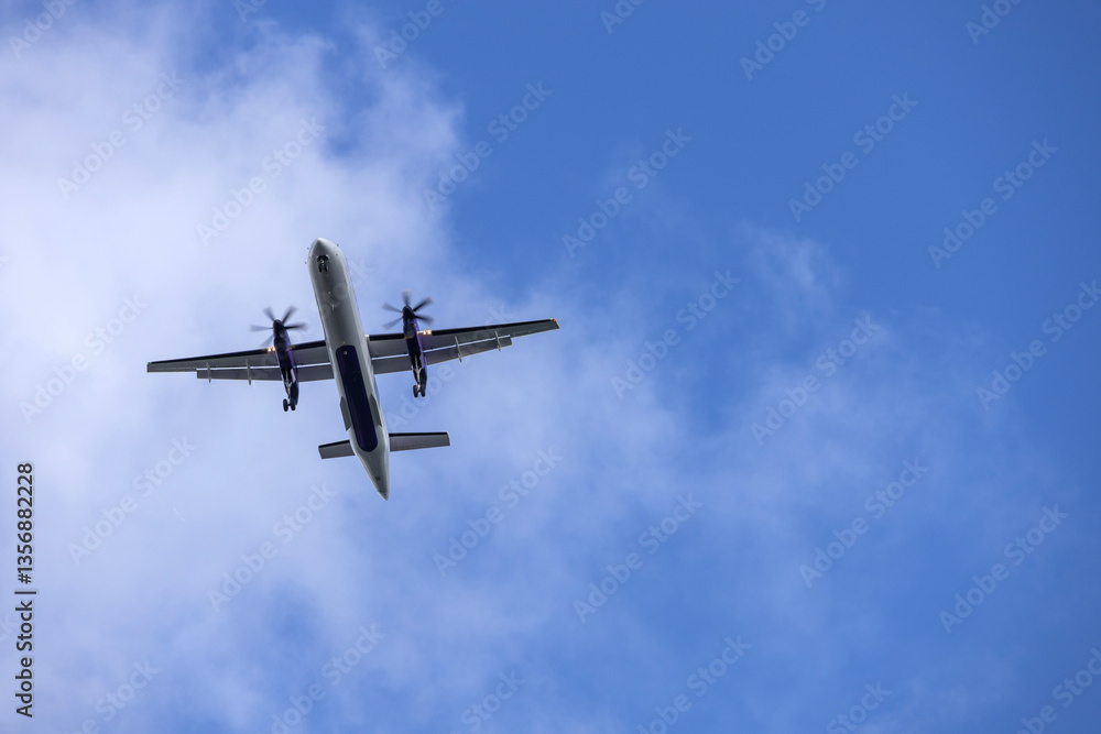 Airplane in blue sky with light clouds over the house Airplane in blue sky with light clouds over the house