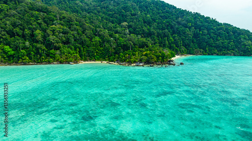 Obraz na plátně A breathtaking aerial view of a secluded Surin islands with crystal-clear turquoise waters, surrounded by lush green vegetation and corel reef