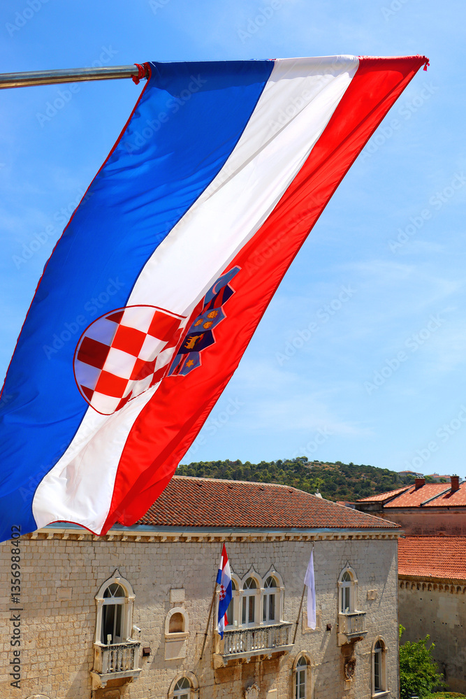 Croatian flag blowing in the wind on the bell tower of The Cathedral of St. Lawrence, landmark in Trogir, Croatia.