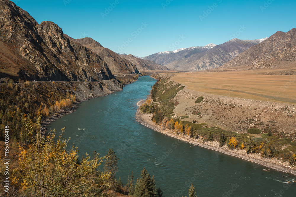 A river flowing through rugged, rocky mountains in the Altai Republic, showcasing the harsh yet stunning natural landscape.