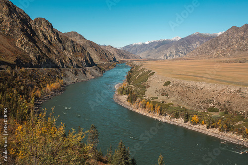 A river flowing through rugged, rocky mountains in the Altai Republic, showcasing the harsh yet stunning natural landscape.