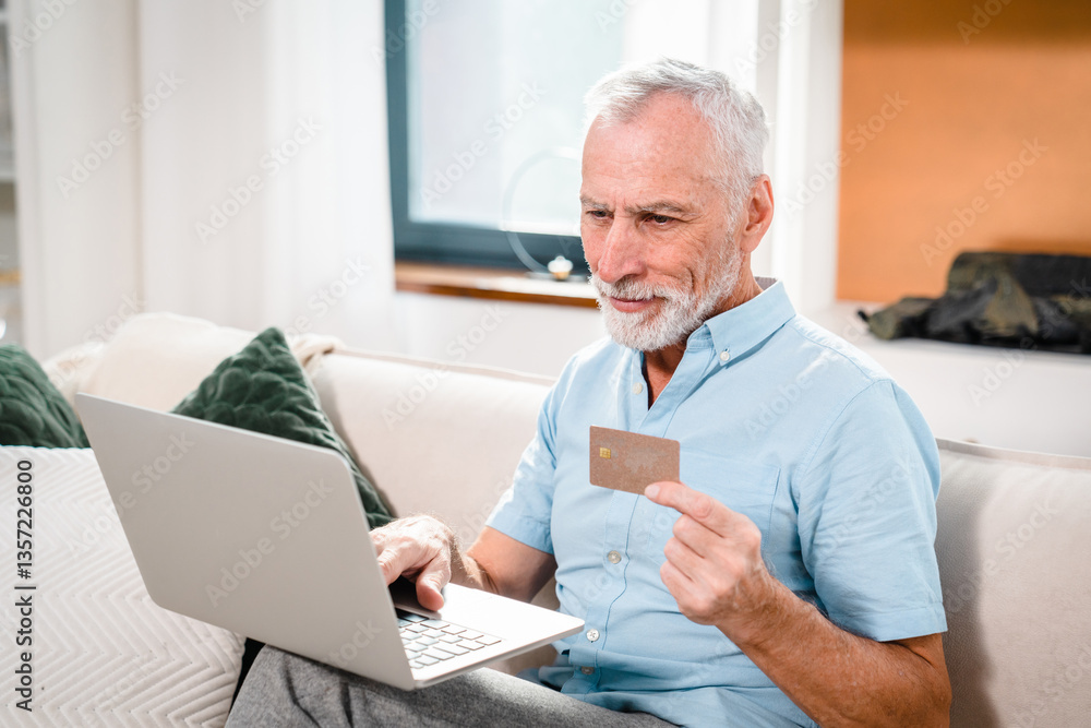 One man senior caucasian male grandfather sit at home use credit card and laptop computer shopping online use internet for online purchase active modern senior looking at screen copy space One man senior caucasian male grandfather sit at home use credit card and laptop computer shopping online use internet for online purchase active modern senior looking at screen copy space