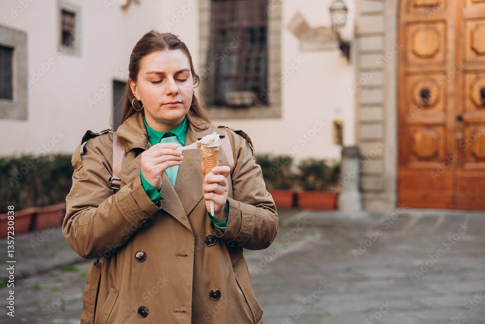 Tasty pistachio ice cream cone in hand. Closeup image of woman hand holding fresh waffle cone with pink ice cream Outdoors, Top Italy food. Lifestyle, travel, people concept.