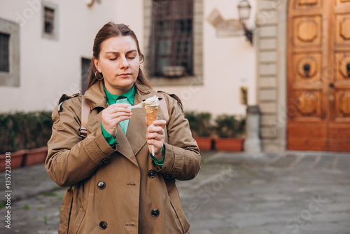 Obraz na płótnie Tasty pistachio ice cream cone in hand. Closeup image of woman hand holding fresh waffle cone with pink ice cream Outdoors, Top Italy food. Lifestyle, travel, people concept. w salonie