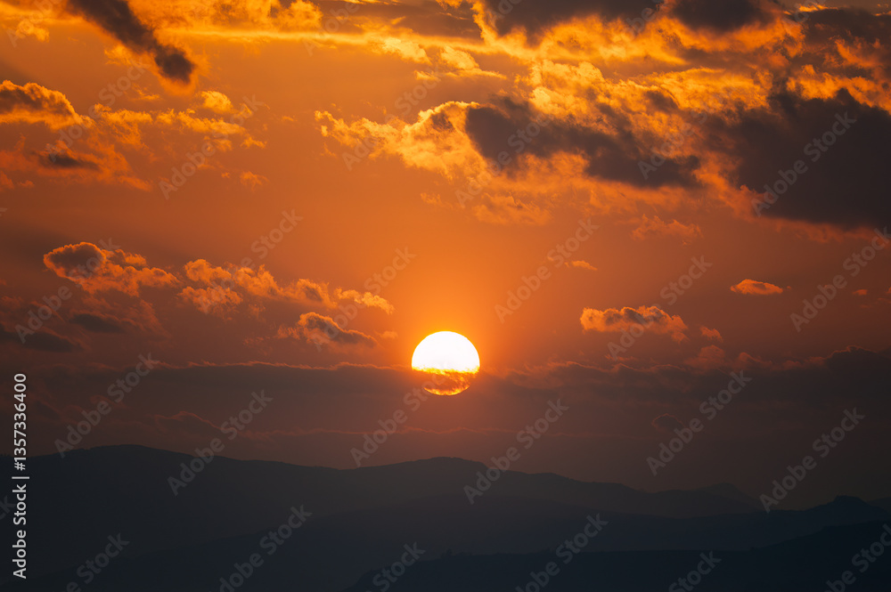 Obraz premium The sun sets over the mountains at dusk