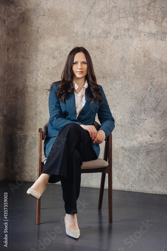 Young Woman in Suit Sitting on Chair Looking at Camera