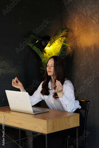 Businesswoman practicing meditation at work for stress relief and focus. Vertical photo