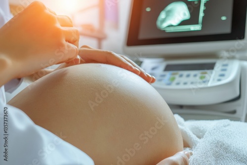 Doctor performing ultrasound on a pregnant woman with a clear ultrasound image of a baby on the screen
