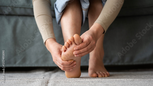 Fotografie Young woman feeling pain in her foot
