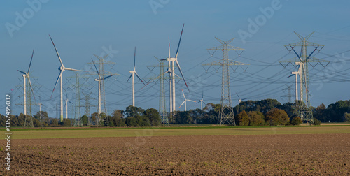 Stromnetz und Strommast Leitungen und im Hintergrund Windkraftanlagen zur Energiegewinnung