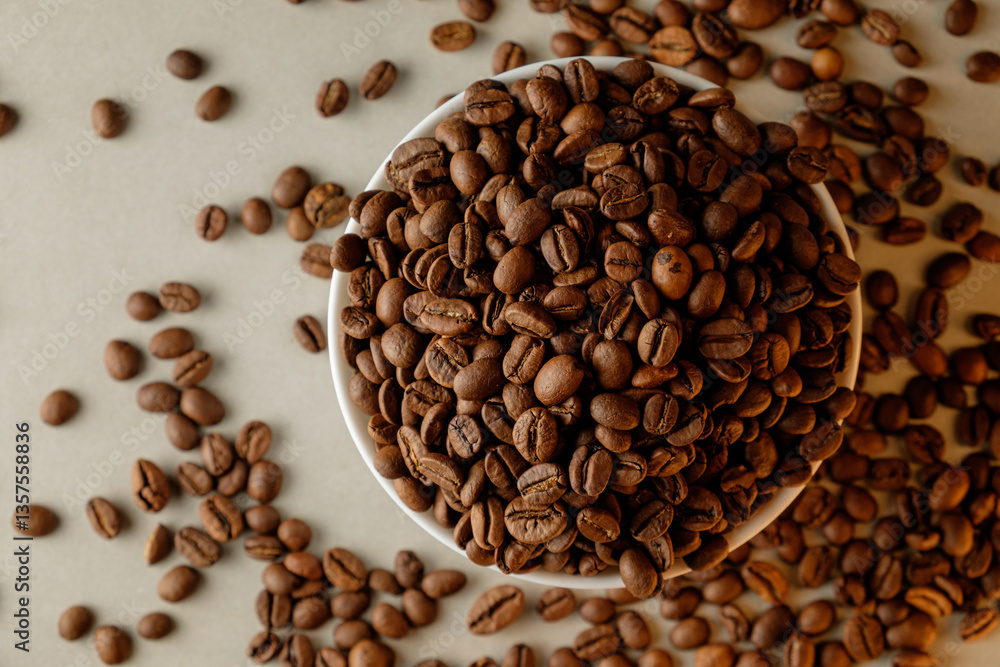 Fototapeta premium Freshly roasted coffee beans spilling onto a rustic table surface