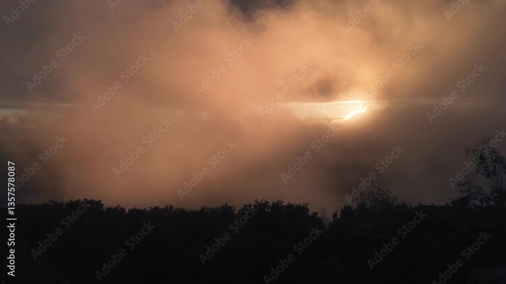 Magical golden sunset above the mountains. Real time rising and swirling mist in the valley. It will be thicker and thicker and at the end covers the sun completely. Zemplen Mountains, Hungary. Magical golden sunset above the mountains. Real time rising and swirling mist in the valley. It will be thicker and thicker and at the end covers the sun completely. Zemplen Mountains, Hungary.