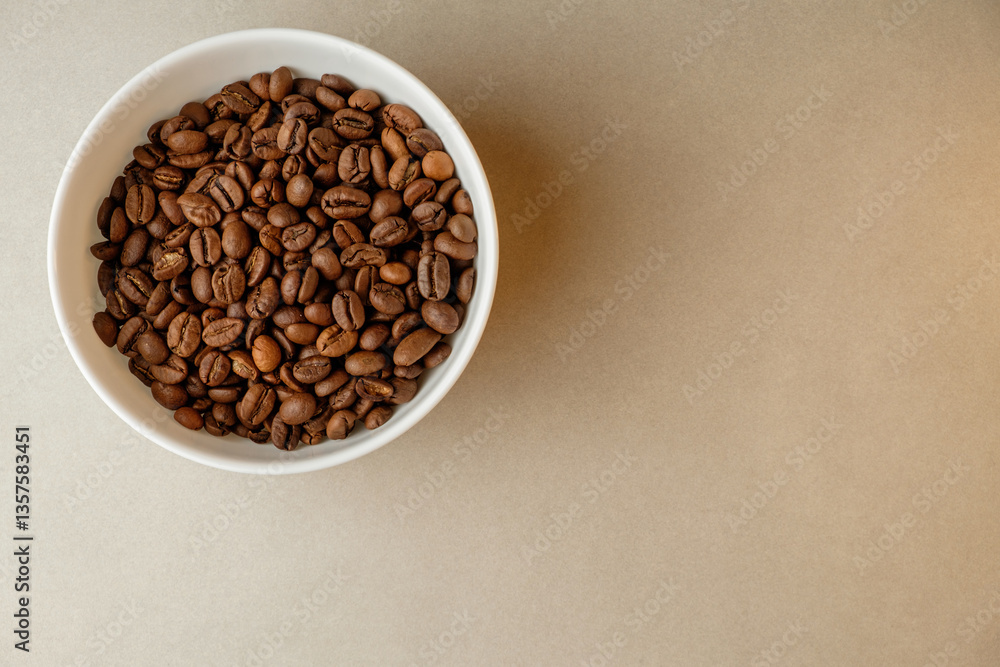 Coffee beans nestled in a white bowl on a neutral background for brewing Coffee beans nestled in a white bowl on a neutral background for brewing