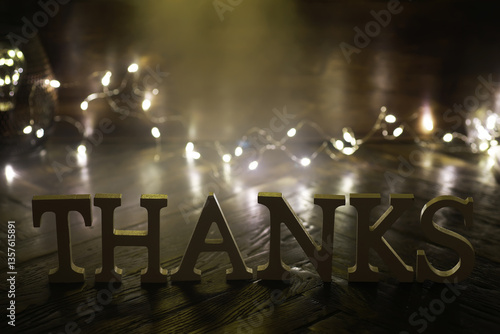 Thanks Sign with Warm Festive Lights on Rustic Wooden Surface